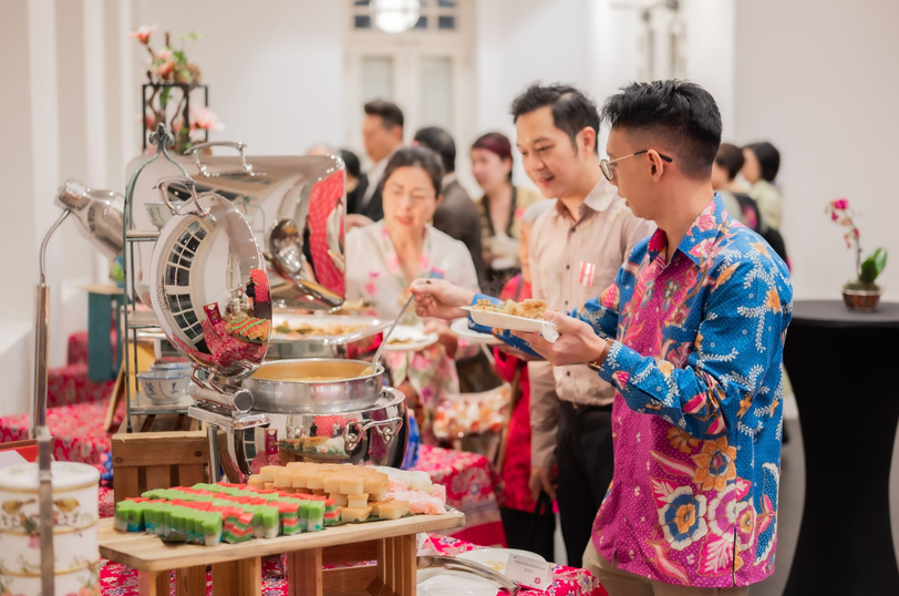 People lined up in front of a buffet table