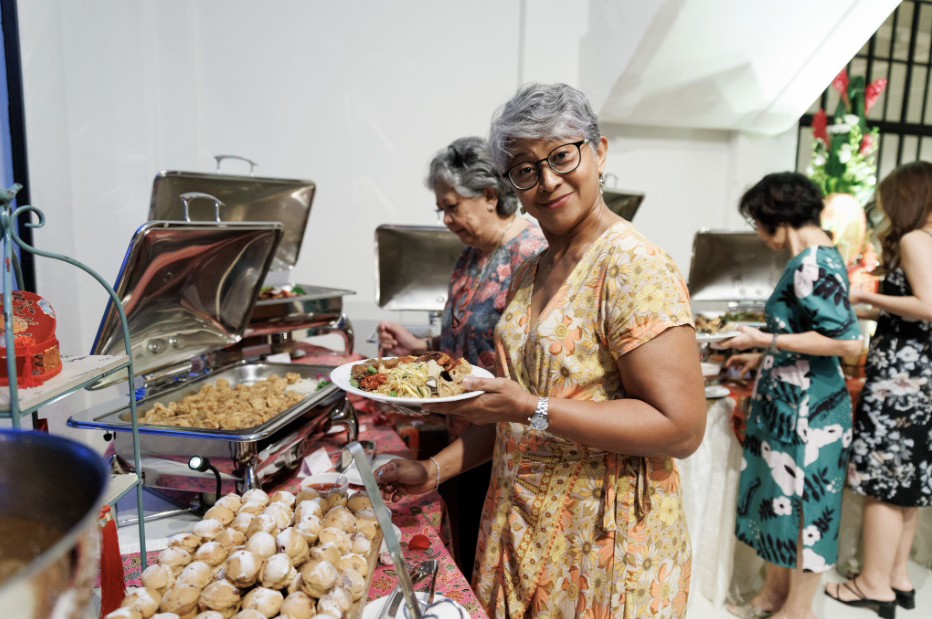 Wedding guests serving themselves at a halal Peranakan buffet spread during a reception in Singapore